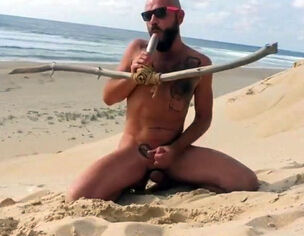 stud porks himself on the beach with a wooden faux-cock